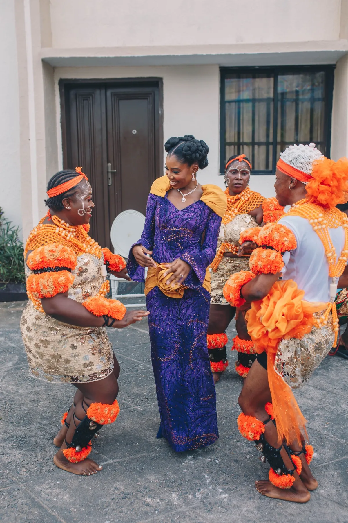 adeilé in purple dancing with women in orange and white at the introduction