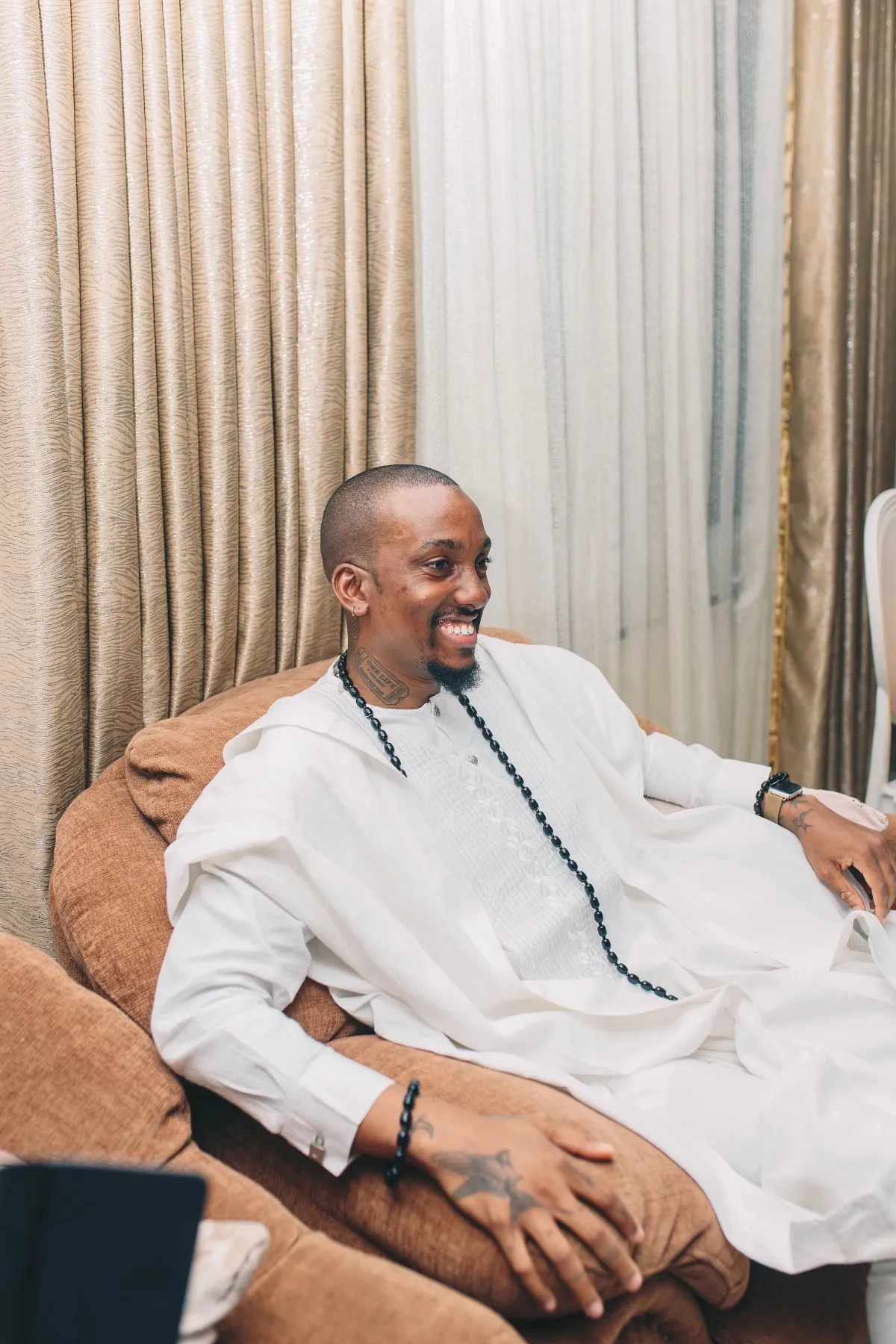 ekanem smiling in an armchair