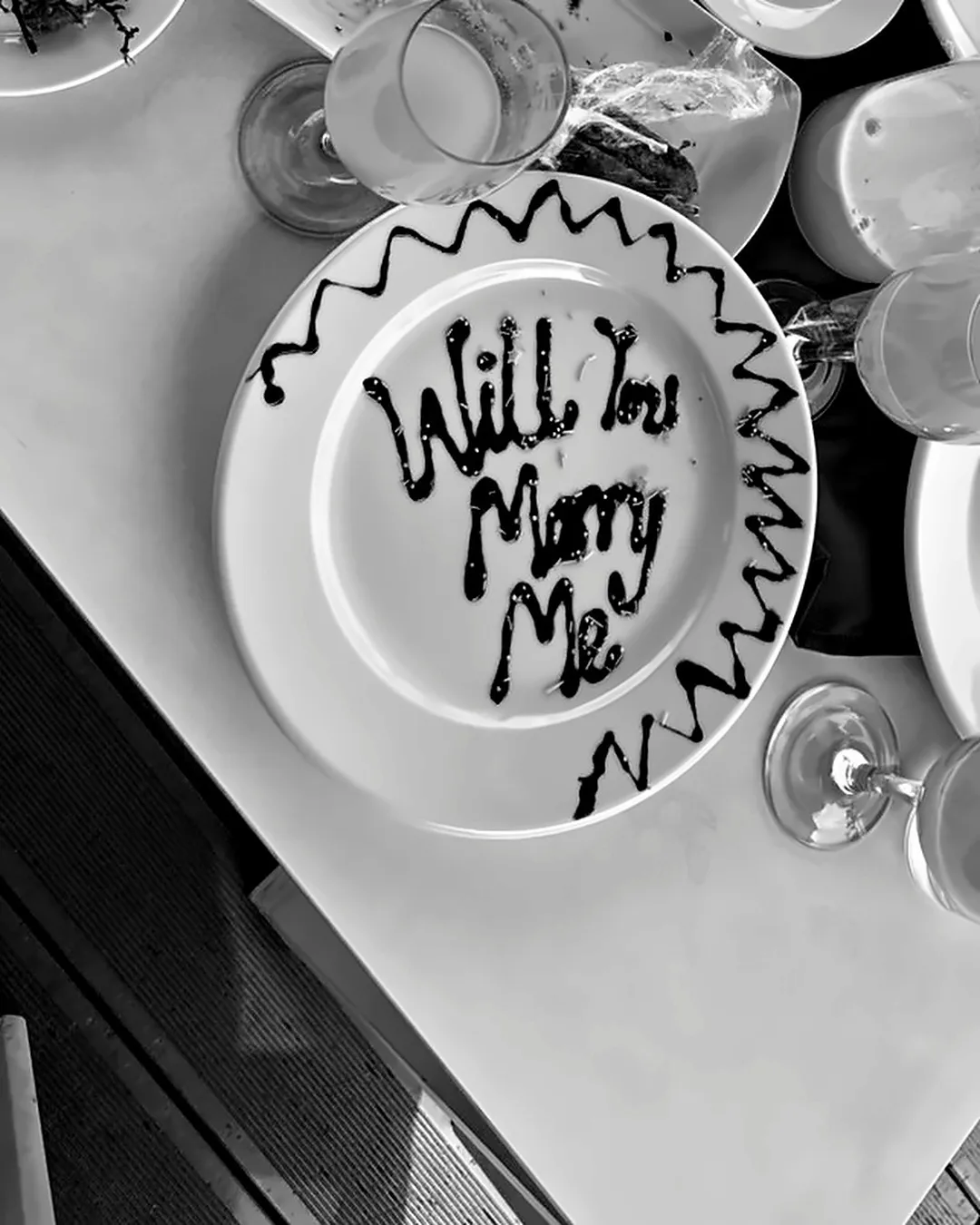 a dessert plate with "will you marry me" piped in chocolate, black and white